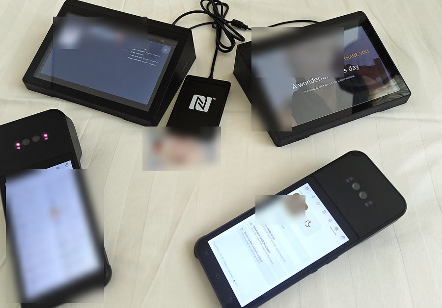The ezSchool kit: two front desks, one running the log and one the notice board, the Emirates ID reader, and two handheld palm readers